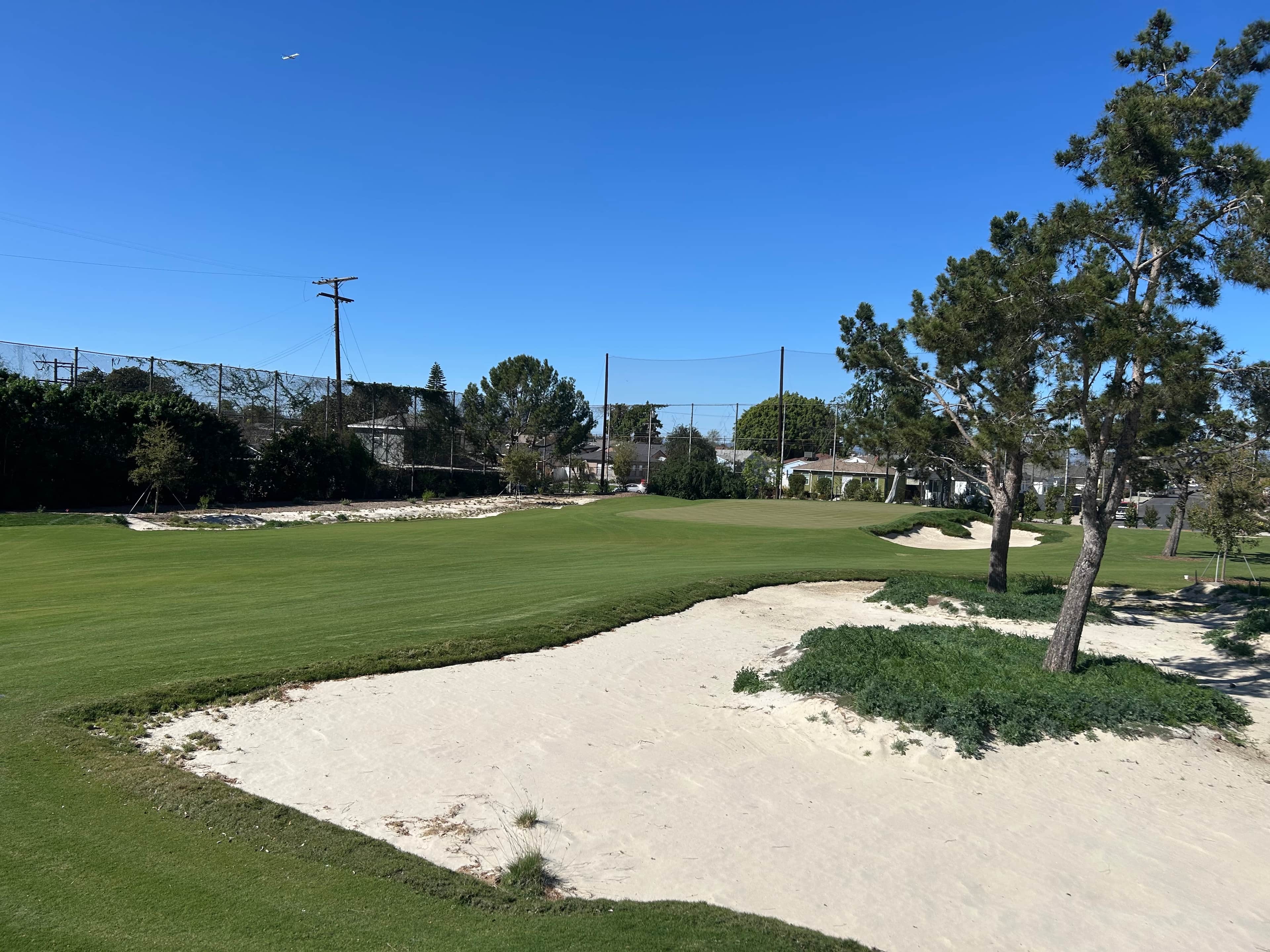 Renovated green framed by sandy waste areas at Maggie Hathaway Golf Course after the Gil Hanse redesign.