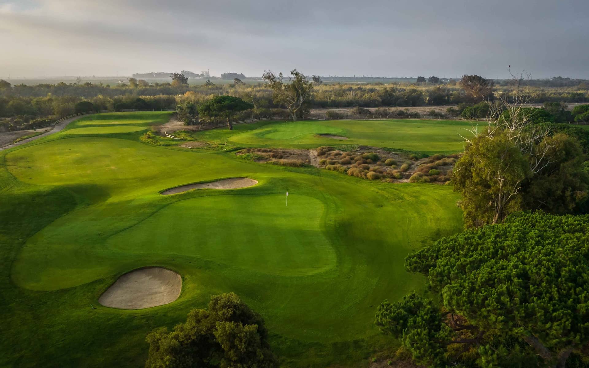 Aerial view of greens, bunkers and native rough at Olivas Links, Ventura.