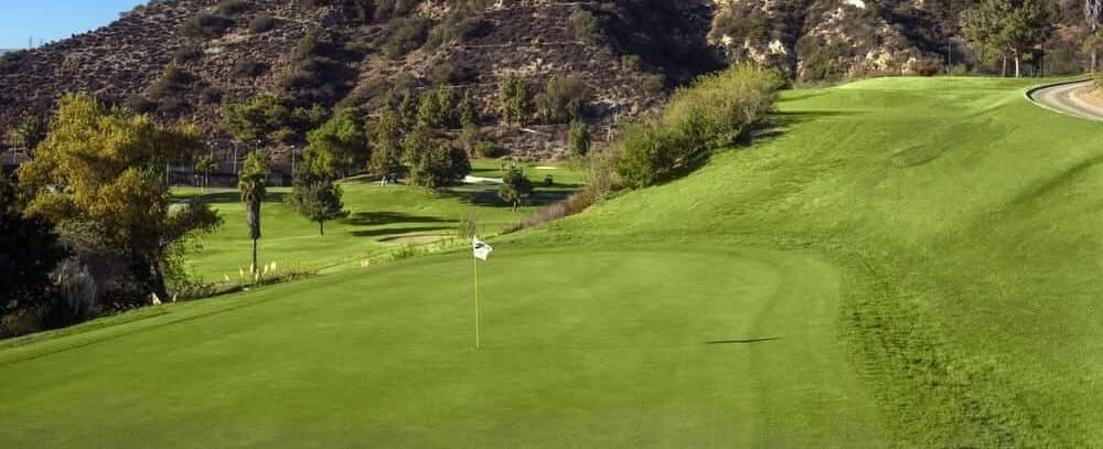 A putting green and fairway set against the hills at Scholl Canyon Golf Course. Photo courtesy Scholl Canyon Golf & Tennis Club (schollcanyongc.com). Used for editorial coverage.