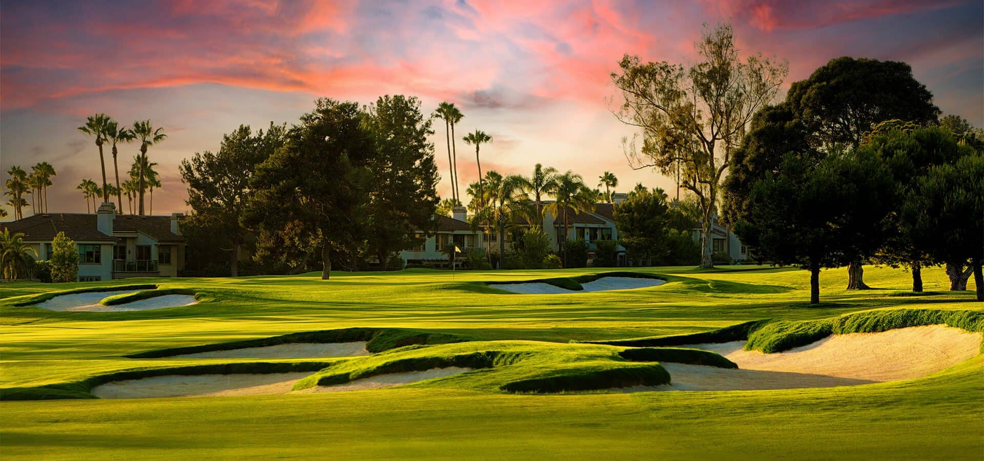 Green, fairway and multiple renovated bunkers at Newport Beach Country Club near sunset.