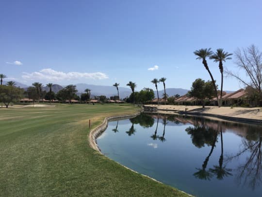On-course view of Palm Desert Resort Country Club: Lakeside fairway with palms.