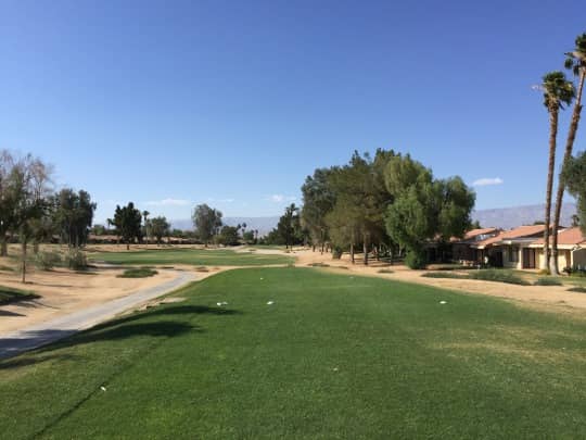 On-course view of Palm Desert Resort Country Club: Tree-lined fairway and cart path.